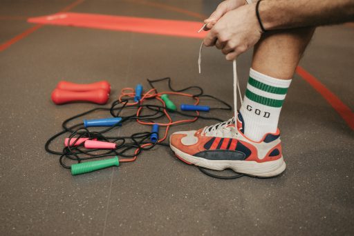 Persona atando sus zapatillas de saltar la cuerda para empezar con una rutina de ejercicios.
